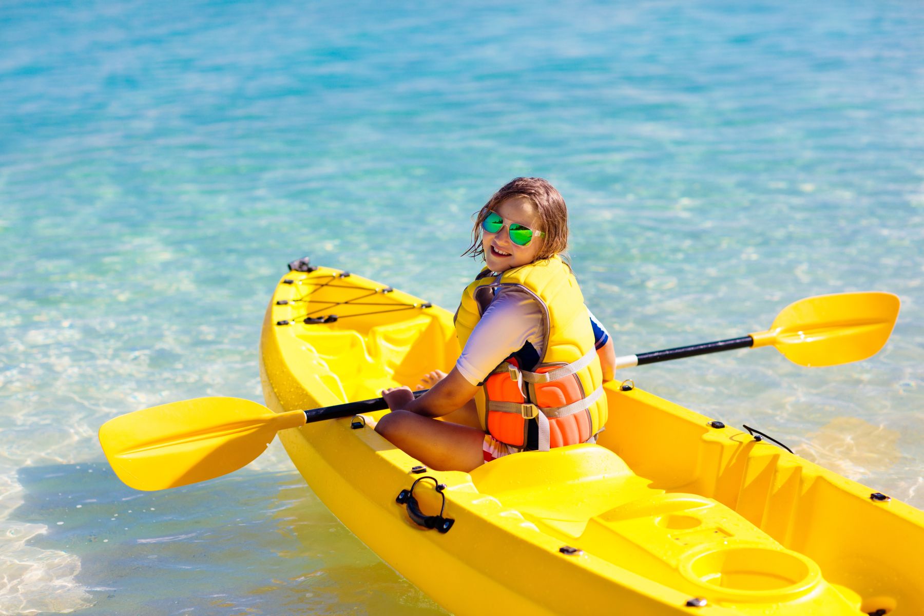 girl in kayak on sunny day at the beach